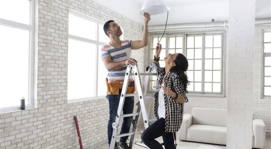 couple installing light fixture ladder safety